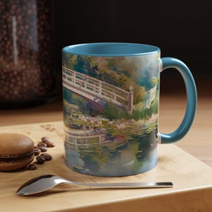 Artistic mug featuring Monet’s water lilies and Japanese bridge, showcasing serene greens, soft pinks, and calm reflections inspired by his iconic garden scenes