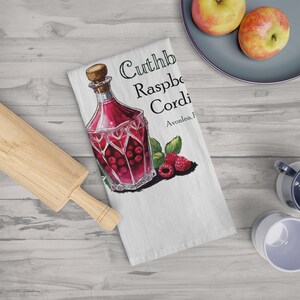 May include: White kitchen towel featuring a watercolor illustration of a raspberry cordial bottle with the text "Cuthb Raspberry Cordi". The bottle is filled with red liquid and raspberries. Fresh raspberries and leaves are also depicted.