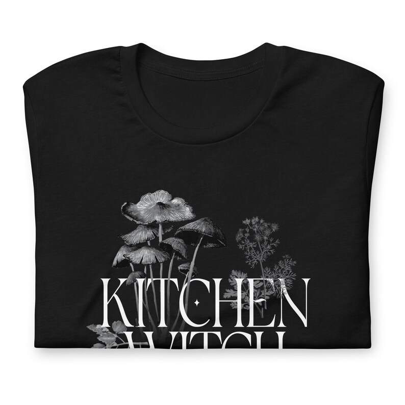 May include: Black t-shirt with a white graphic of mushrooms and the text "Kitchen Witch".