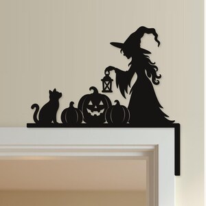 May include: A black silhouette wall decoration featuring a witch holding a lantern, a cat, and three pumpkins, including one jack-o'-lantern. The text "Kleine Details. Große Halloween-Stimmung." and "Kürbishexe" is visible along with the "Prints by Eri" logo.