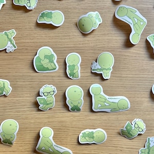 K&ouml;nnte beinhalten: Ein Set mit 16 gr&uuml;nen Vinyl-Aufklebern mit verschiedenen Illustrationen einer einfachen gr&uuml;nen Strichfigur in verschiedenen Posen und Situationen. Die Aufkleber enthalten Text wie "Busy", "Can't see I'm busy", "Noooooooo" und "Can't see I'm busy".