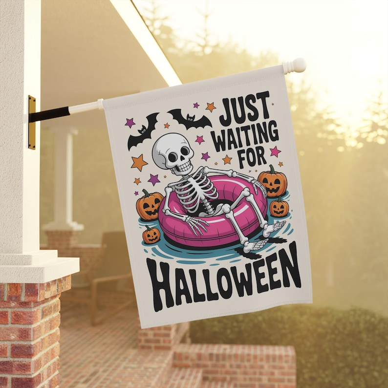 May include: A white Halloween flag with a skeleton relaxing in a pink inner tube, surrounded by pumpkins and stars. The flag reads "JUST WAITING FOR HALLOWEEN" in black text, with bats above.