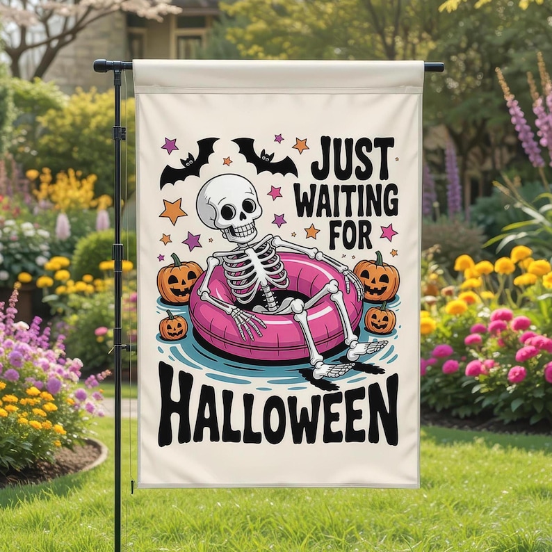 May include: A Halloween garden flag featuring a skeleton in a pink inner tube surrounded by pumpkins. The flag has the text "JUST WAITING FOR HALLOWEEN" in black. Bats and stars decorate the top of the flag.