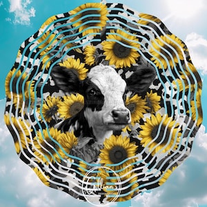 May include: A black and white cow's face is at the centre of a circular design featuring yellow sunflowers and a black and white cow-print pattern. The background is a blue sky with white clouds. The text "Gillian's Design Studio" is at the bottom.