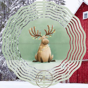May include: A charming illustration of a reindeer decorated with fairy lights, set in a winter scene. The reindeer is brown with large antlers and is sitting in the snow. The background features a red barn and snow-covered trees. The image is framed by a decorative green and silver border.
