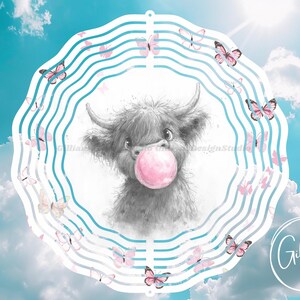 Peut inclure: Un mobile en métal avec un adorable dessin animé de vache écossaise soufflant une bulle rose. Le mobile est décoré de papillons roses et présente un design à rayures bleues et blanches.
