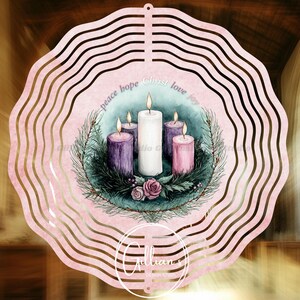 Può includere: Un mulinello a vento in metallo rosa con un design ad acquerello di quattro candele in una ghirlanda. Le candele sono viola, bianche e rosa. Il testo "peace hope Christ love joy" è scritto intorno alle candele.