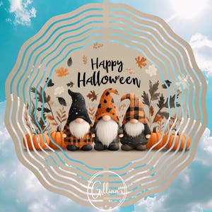 Op de afbeelding: Een Halloween-afbeelding met drie kabouters met geruite en gestippelde hoeden, witte baarden en oranje pompoenen. De woorden "Happy Halloween" staan boven de kabouters, tegen een achtergrond van de lucht.