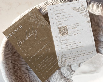 Puede incluir: Dos tarjetas de invitación para un brunch nupcial. Una tarjeta es de color marrón claro con las palabras "Brunch & Bubbly" y detalles florales. La otra tarjeta es blanca con detalles del evento y un código QR. Las tarjetas están sobre una superficie tejida.