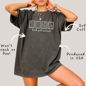 May include: Dark gray t-shirt with the text "book girl summer" and four small framed illustrations. The shirt is made of soft cotton and is produced in the USA. The design is made to not crack or peel.