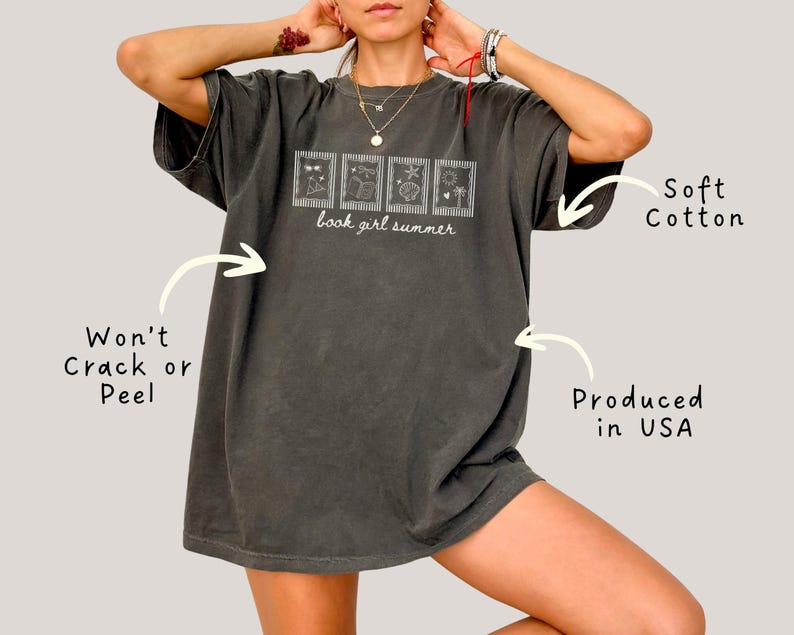 May include: Dark gray t-shirt with the text "book girl summer" and four small framed illustrations. The shirt is made of soft cotton and is produced in the USA. The design is made to not crack or peel.