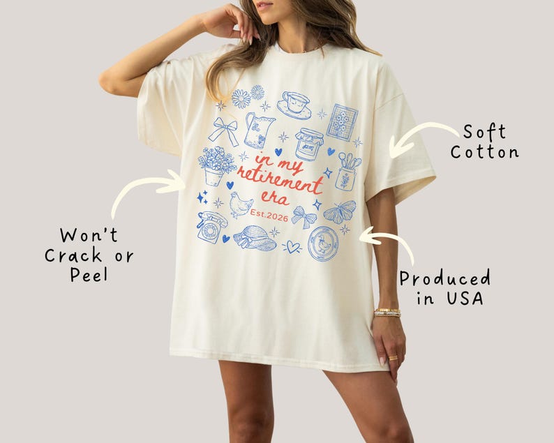 K&ouml;nnte beinhalten: Cremefarbenes &uuml;bergro&szlig;es T-Shirt mit blauem und rotem Grafikdesign. Das Design enth&auml;lt verschiedene Illustrationen und den Text "in my retirement era Est.2026". Das Shirt besteht aus weicher Baumwolle und wird in den USA hergestellt.