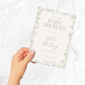 K&ouml;nnte beinhalten: Eine wei&szlig;e Babyparty-Einladung mit floralem Rand. Der Text lautet: "Bitte feiern Sie mit uns eine Babyparty zu Ehren von Kate Darling Samstag, der Erste Mai um 16:00 Uhr 123 Baby Lane, Austin, TX Bitte melden Sie sich bis zum [Datum] an"