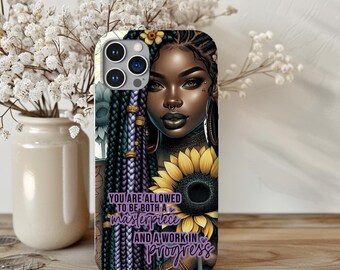 May include: A phone case with a colorful illustration of a woman with braids, a sunflower, and the text "You are allowed to be both a masterpiece and a work in progress".