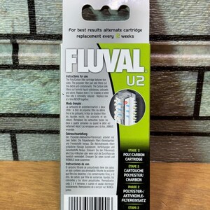 Puede incluir: Caja de cartucho Poly-Carbon Fluval U2, principalmente verde y blanca. El logotipo de Fluval y la informaci&oacute;n del producto son visibles. El texto incluye instrucciones y la frase "reemplazo cada 2 semanas".