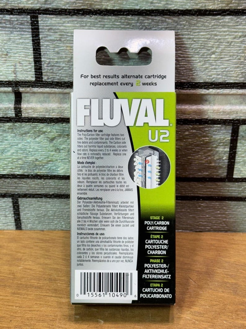 Puede incluir: Caja de cartucho Poly-Carbon Fluval U2, principalmente verde y blanca. El logotipo de Fluval y la informaci&oacute;n del producto son visibles. El texto incluye instrucciones y la frase "reemplazo cada 2 semanas".