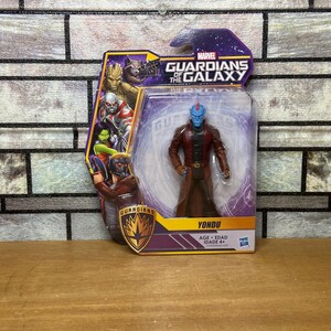 May include: A Marvel Guardians of the Galaxy action figure of Yondu in a sealed package. The figure has a blue face, red mohawk, and a red coat. The packaging features other characters from the movie.