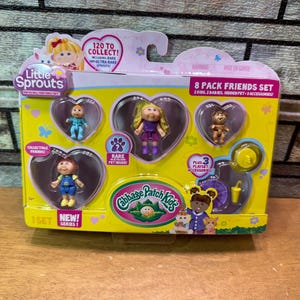 May include: A yellow Cabbage Patch Kids 8-pack Friends Set. The package includes several small dolls in heart-shaped compartments. The packaging features the text "Little Sprouts", "120 to Collect!", and "Rare Pet Inside!"