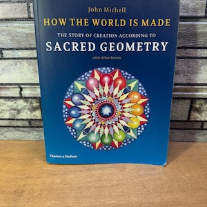 Könnte beinhalten: Ein blaues Buch mit dem Titel "How the World is Made: The Story of Creation According to Sacred Geometry" von John Michell mit Allan Brown. Der Umschlag zeigt ein farbenfrohes Mandala mit einem Stern in der Mitte.