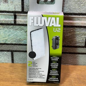 Puede incluir: Un paquete de cartuchos de filtro para acuario Fluval U2. La caja es verde y blanca, con el logotipo de Fluval e informaci&oacute;n del producto. El paquete incluye un cartucho de poli/carbono de etapa 2. El texto indica que atrapa residuos finos.