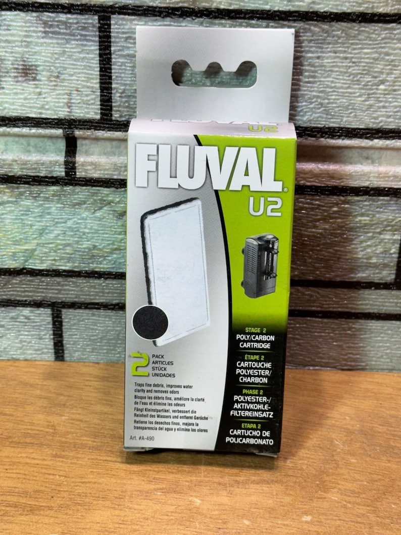 Puede incluir: Un paquete de cartuchos de filtro para acuario Fluval U2. La caja es verde y blanca, con el logotipo de Fluval e informaci&oacute;n del producto. El paquete incluye un cartucho de poli/carbono de etapa 2. El texto indica que atrapa residuos finos.