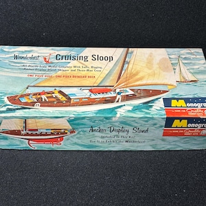 May include: Vintage model kit box for a Wanderlust Cruising Sloop. The box features a detailed illustration of a sailboat with sails, and the text "Anchor Display Stand" and "Monogram" are also visible.