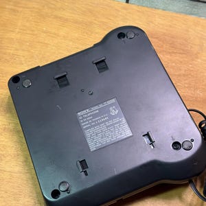 Puede incluir: Un tel&eacute;fono ID Sony negro, modelo IT-10500, con una etiqueta que incluye el texto "MADE IN TAIWAN R.O.C." y "SERIAL NO. 119685." El tel&eacute;fono tiene forma rectangular con esquinas redondeadas y varios botones y puertos peque&ntilde;os.
