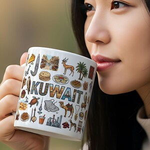 May include: White ceramic mug with the word "KUWAIT" and various illustrations of Kuwaiti culture. The mug is held by a person. The illustrations include a camel, palm trees, and traditional food.
