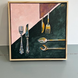 May include: A framed painting featuring stylized silverware. The artwork is divided diagonally, with a pink and brown upper section and a dark green lower section. Silver forks, knives, spoons, and a wrench are depicted.