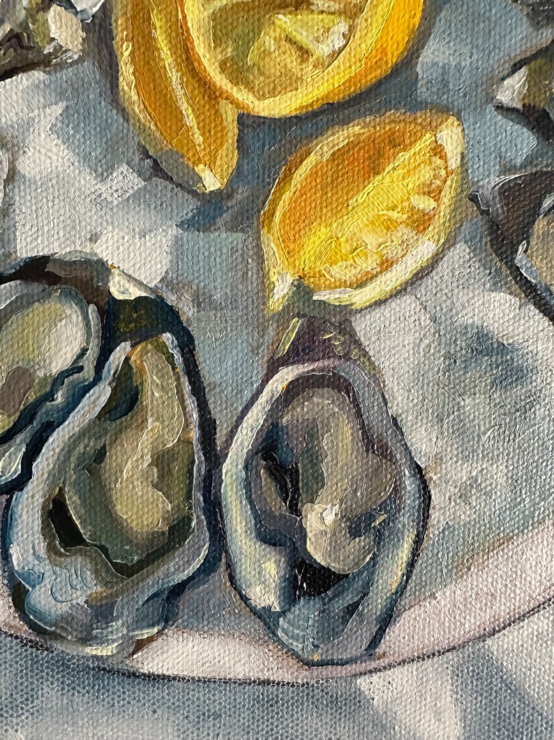 May include: A close-up of a white plate with several oysters and lemon slices. The oysters are open and show their pearly interiors. The lemon slices are yellow and juicy.