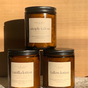 Puede incluir: Tres frascos de vidrio &aacute;mbar con tapas negras que contienen loci&oacute;n de sebo batida. Los frascos est&aacute;n etiquetados como "simply tallow", "vanilla lotion" y "tallow lotion".