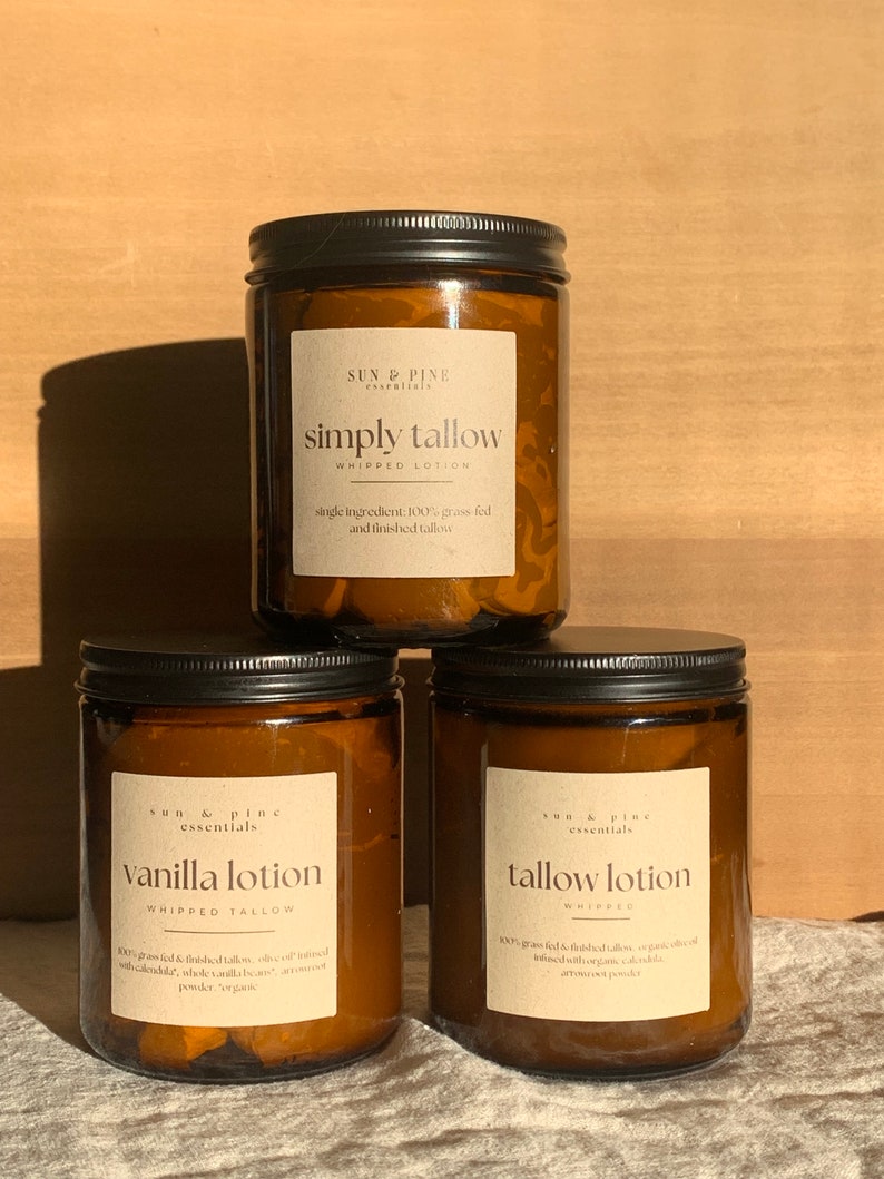 Puede incluir: Tres frascos de vidrio &aacute;mbar con tapas negras que contienen loci&oacute;n de sebo batida. Los frascos est&aacute;n etiquetados como "simply tallow", "vanilla lotion" y "tallow lotion".