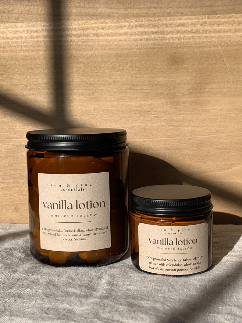 Puede incluir: Dos frascos de vidrio &aacute;mbar con tapas negras que contienen loci&oacute;n de vainilla. Las etiquetas dicen "sun & pine essentials vanilla lotion whipped tallow". El frasco m&aacute;s grande tiene el texto "100% sebo de res alimentado con pasto y terminado, aceite de oliva infundido con cal&eacute;ndula, granos de vainilla enteros, polvo de ra&iacute;z de flecha, "org&aacute;nico". El frasco m&aacute;s peque&ntilde;o tiene el texto "100% sebo de res alimentado con pasto y terminado, aceite de oliva infundido con cal&eacute;ndula, granos de vainilla enteros, polvo de ra&iacute;z de flecha, "org&aacute;nico".