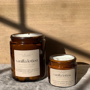 Puede incluir: Dos frascos de vidrio &aacute;mbar de loci&oacute;n de vainilla con etiquetas blancas. Las etiquetas dicen "sun & pine essentials" y "vanilla lotion whipped tallow". El texto en las etiquetas describe los ingredientes, que incluyen sebo alimentado con pasto, aceite de oliva, cal&eacute;ndula, granos de vainilla enteros y polvo de ra&iacute;z de flecha.