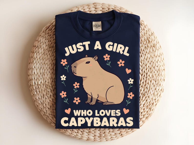 May include: A navy blue t-shirt with a graphic of a capybara and the text "Just a girl who loves capybaras".
