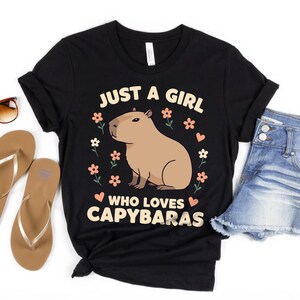 May include: Black t-shirt with a graphic of a capybara and the text "Just a girl who loves capybaras".