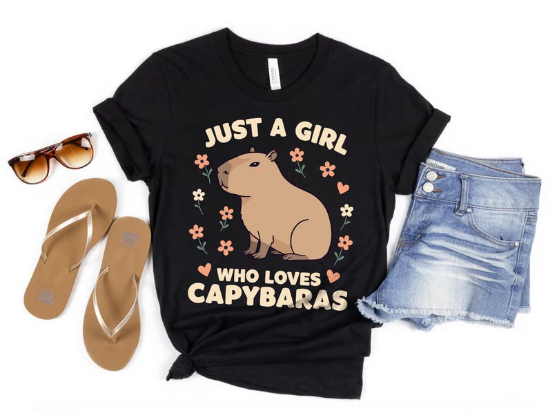 May include: Black t-shirt with a graphic of a capybara and the text "Just a girl who loves capybaras".