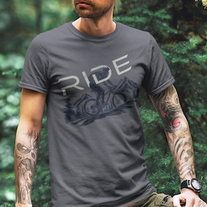 May include: A dark gray t-shirt with a graphic of a mountain biker and the word "RIDE" printed on the front.
