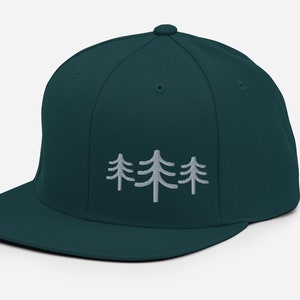 May include: A dark teal blue baseball cap with a white embroidered design of three stylized pine trees.
