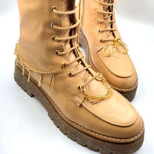 Fashion-forward gold chain accessory for boots, featuring a unique charm.