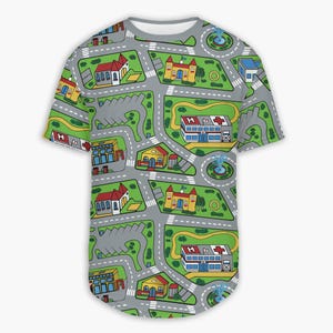 May include: A gray, short-sleeved t-shirt featuring a colorful city map design. The map includes roads, buildings, parking lots, and fountains. Buildings include a hospital, church, and houses. The shirt has a rounded hem.