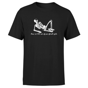 May include: Black t-shirt with a white skeleton graphic and the text "draw me like one of your french girls".
