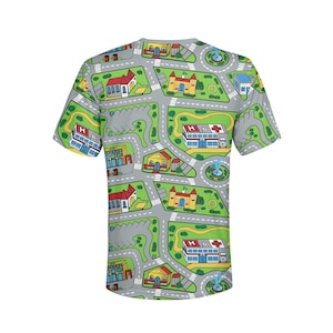 May include: A short-sleeved t-shirt with a playful city map design. The shirt features roads, buildings, green spaces, and fountains in a colorful pattern. The design includes hospitals, houses, and parking lots.
