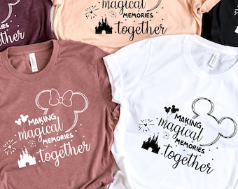 May include: Five t-shirts in different colours with a white graphic of Mickey Mouse ears with a bow and the text "Making magical memories together" on each shirt.
