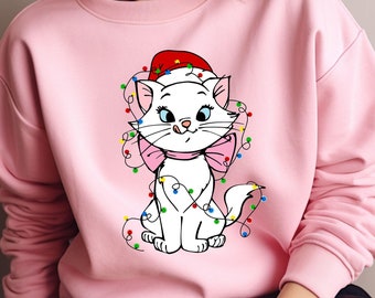 May include: A light pink sweatshirt featuring a cartoon cat wearing a Santa hat and wrapped in colorful Christmas lights. The cat has a pink bow and blue eyes. The sweatshirt is a crew neck style.