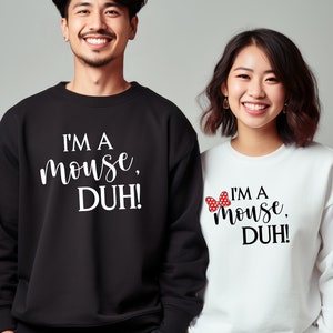 May include: Two people wearing black and white sweatshirts with the text "I'm a mouse, DUH!" on them. The woman's sweatshirt has a red and white bow on it.