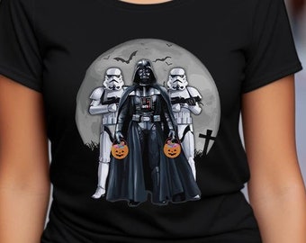 Op de afbeelding: Een zwart T-shirt met een afbeelding van Darth Vader en twee Stormtroopers die jack-o'-lanterns vasthouden voor een volle maan. De afbeelding is in cartoon-stijl.