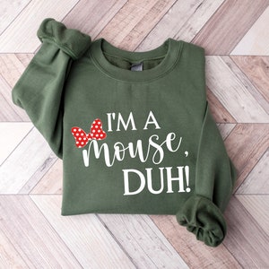 May include: A green sweatshirt with a white graphic that says "I'm a mouse, DUH!" and a red bow with white polka dots.