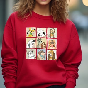 Pu&ograve; includere: Una felpa rossa con una griglia di nove illustrazioni di cani dei cartoni animati. Ogni cane &egrave; in un quadrato separato, che mostra diverse razze ed espressioni. La felpa &egrave; di colore rosso tinta unita.