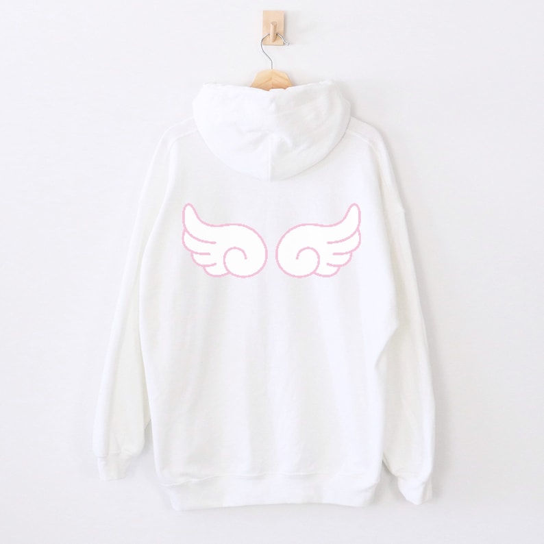 May include: White hooded sweatshirt with pink angel wings printed on the back.